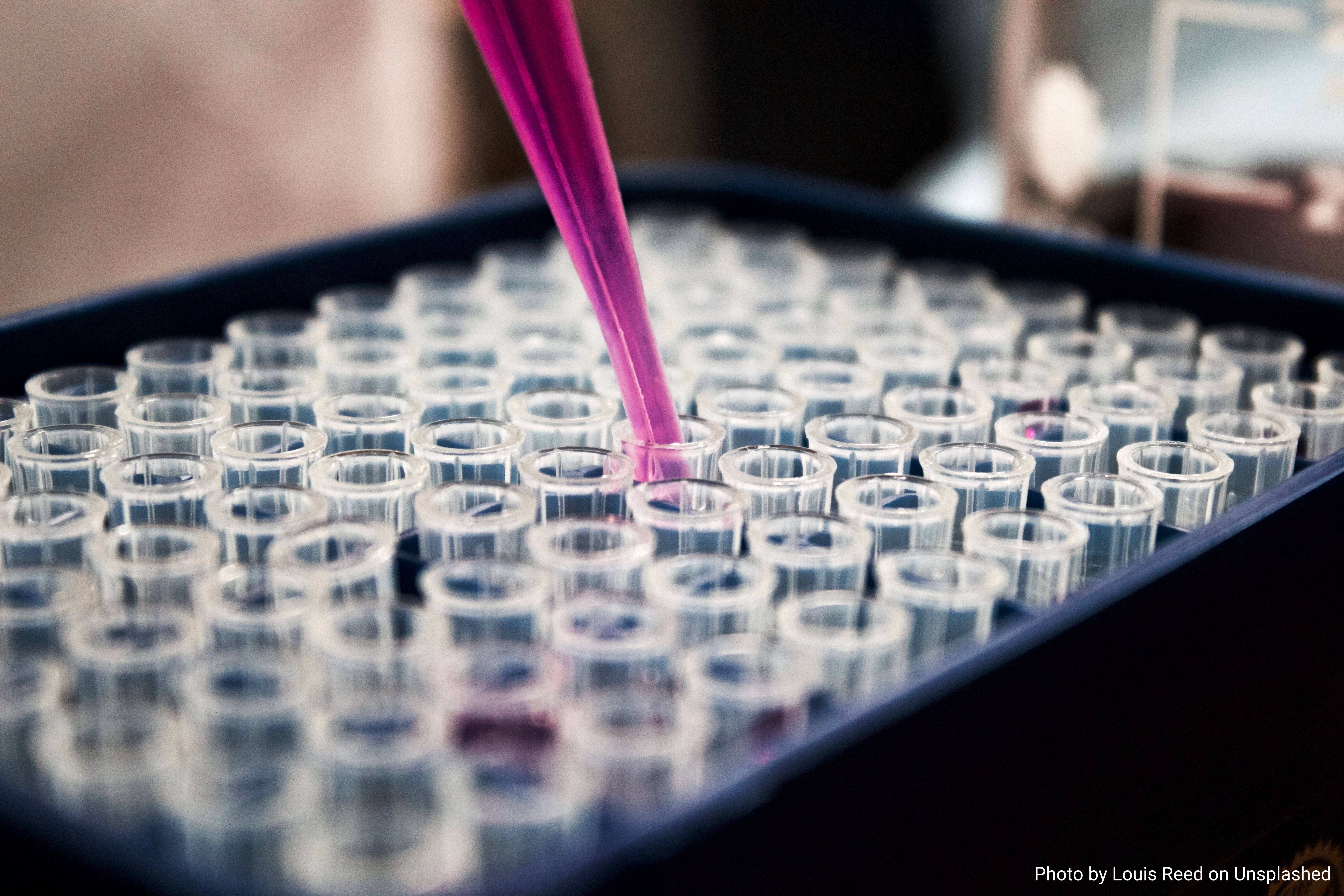 Contenitori per liquidi chimici su sfondo fucsia